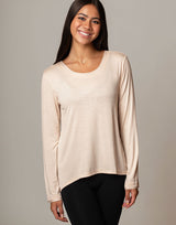 woman wearing ivory vanilla colored long sleeve top on grey background
