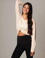 woman wearing ivory vanilla colored long sleeve top on grey background