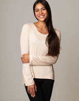 woman wearing ivory vanilla colored long sleeve top on grey background
