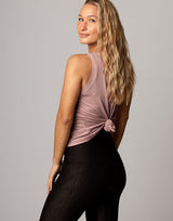 woman wearing pale mauve colored tank on grey background
