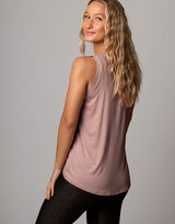 woman wearing pale mauve colored tank on grey background