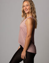woman wearing pale mauve colored tank on grey background