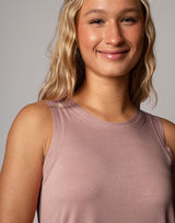 woman wearing pale mauve colored tank on grey background
