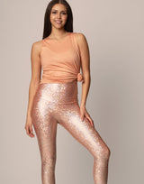 woman wearing peach colored tank on grey background