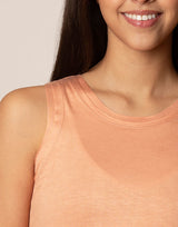 woman wearing peach colored tank on grey background