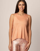 woman wearing peach colored tank on grey background