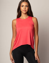 woman wearing tank in coral on grey background