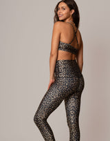 woman wearing leopard print sports bra against grey background