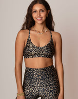 woman wearing leopard print sports bra against grey background