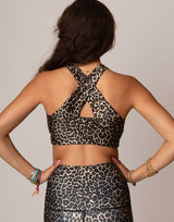 woman wearing leopard printed sports crop on grey background