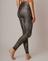 woman wearing leopard printed legging on grey background
