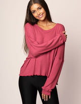woman wearing oversized waffle knit long sleeve top in berry on grey background
