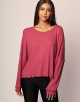 woman wearing oversized waffle knit long sleeve top in berry on grey background