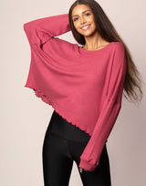 woman wearing oversized waffle knit long sleeve top in berry on grey background
