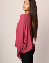 woman wearing oversized waffle knit long sleeve top in berry on grey background