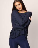 woman wearing oversized waffle knit long sleeve top in navy on grey background