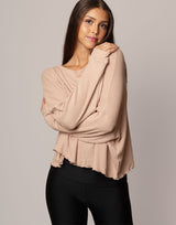 woman wearing oversized waffle knit long sleeve top in oatmeal beige on grey background