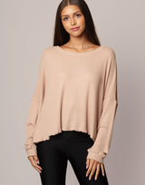 woman wearing oversized waffle knit long sleeve top in oatmeal beige on grey background