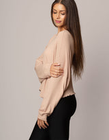 woman wearing oversized waffle knit long sleeve top in oatmeal beige on grey background