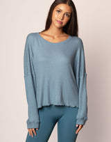 woman wearing oversized waffle knit long sleeve top in ocean blue on grey background