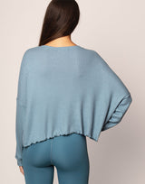 woman wearing oversized waffle knit long sleeve top in ocean blue on grey background