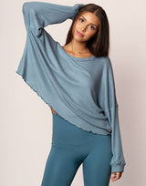woman wearing oversized waffle knit long sleeve top in ocean blue on grey background