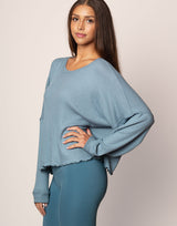 woman wearing oversized waffle knit long sleeve top in ocean blue on grey background