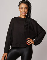 woman wearing pullover sweater in black on grey background