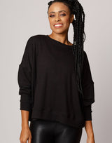 woman wearing pullover sweater in black on grey background