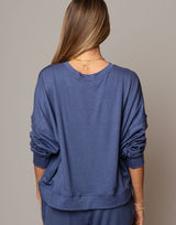 Person wearing a blue sweatshirt against a neutral background