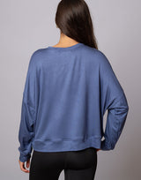 woman wearing denim blue colored pullover sweater on grey background