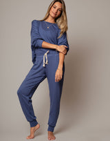 Woman wearing a blue loungewear set against a plain background