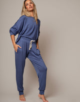 Woman wearing a blue loungewear set against a neutral background