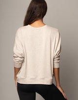 woman wearing pullover sweater top in oatmeal beige on grey background