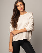 woman wearing pullover sweater top in oatmeal beige on grey background