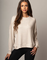 woman wearing pullover sweater top in oatmeal beige on grey background