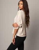 woman wearing pullover sweater top in oatmeal beige on grey background