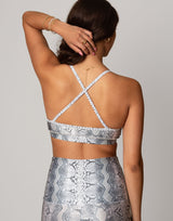 woman wearing white python printed sports bra on grey background