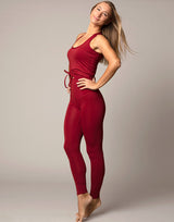 woman wearing legging and tank top set in cranberry red on grey background