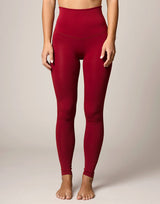 woman wearing legging in cranberry red on grey background