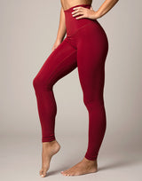 woman wearing legging in cranberry red on grey background