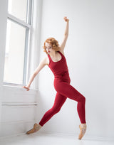 woman wearing tank top and legging set in cranberry red in a studio