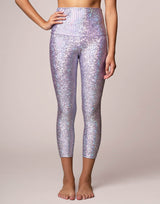 woman wearing legging with mermaid pattern of lavender purple colored sparkling fish scales on grey background