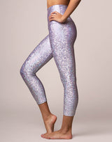 woman wearing legging with mermaid pattern of lavender purple colored sparkling fish scales on grey background