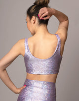 woman wearing v neck crop top with mermaid pattern of lavender purple colored sparkling fish scales on grey background