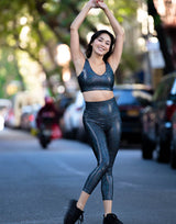 woman wearing legging and v neck crop top set with mermaid pattern of midnight black colored sparkling fish scales outdoors