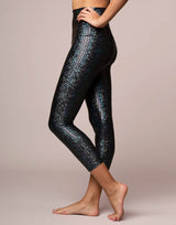 woman wearing legging with mermaid pattern of midnight black colored sparkling fish scales on grey background