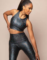 woman wearing crop top with mermaid pattern of midnight black colored sparkling fish scales on grey background