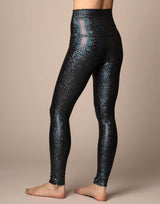 woman wearing sneaker length legging with mermaid pattern of midnight black colored sparkling fish scales on grey background