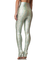 woman wearing long legging with mermaid pattern of mint colored sparkling fish scales on grey background